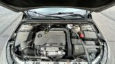 Open-hood view of a car engine bay, with an EcoTec engine cover and battery visible among hoses and components.