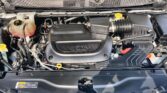 Front view of a vehicle’s engine bay with a black plastic engine cover labeled 3.6L, coolant reservoir, and air intake on the right.