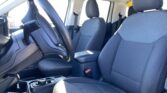 Car interior showing the driver’s seat, steering wheel, and center console with blue fabric seats in the front cabin