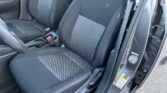 Front seats of a dark car interior with black fabric and diamond-pattern center panels; center console and seat belts visible on either side.