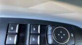 Close-up of power window controls and a circular multi-directional control knob on a car door panel.