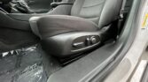 Front passenger-side view of a car interior showing the driver's seat with manual/electronic adjustment controls, center console, and door frame.
