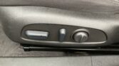Close-up of a car seat side panel with two adjustment levers and a round knob for seating position and lumbar support.