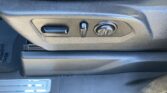 Side view of a car seat's power adjustment panel: a horizontal slider, a small vertical lever, and a round dial for seat tuning.
