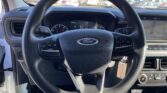 Steering wheel and dashboard of a Ford vehicle, with steering wheel controls and a key tag hanging from the ignition area.