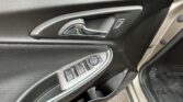Car interior: driver's side door panel with chrome door handle, power window controls, and lock buttons.
