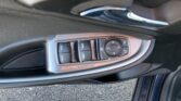 Driver-side door panel with window and mirror controls, chrome door handle visible nearby