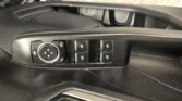 Driver-side door control panel with a circular joystick for mirror adjustment and four window switches.