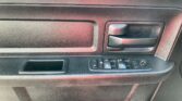 Car interior door panel with a textured black surface, door handle, and power window control buttons.