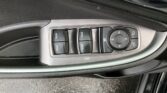 Driver-side car window and mirror control panel with four window switches and a circular directional pad for mirror adjustment in a gray plastic housing.