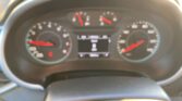 Blurred car instrument cluster with two large dials (speedometer and tachometer) and a central digital display still visible in the middle panel, red needles present.