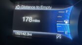 Car dashboard display showing Distance to Empty at 178 miles, with fuel gauge on the right and odometer reading 52,142.3 miles in the bottom left.