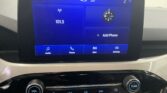 Infotainment touchscreen home screen: time 4:51, temp 58°, left home icon, large 101.5 radio tile, compass widget on the right, and a tile labeled “Add Phone”; bottom navigation shows Audio, Phone, Apps, Settings.