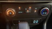 Car climate control panel: left circular dial with orange light, middle row of buttons for defrost, air flow, and A/C, right circular temperature dial with blue/red gradient.