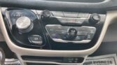 Car center console with a rotary gear shifter (P R N D L) on the left and a large volume knob, climate and hazard controls in the middle, and USB/Aux ports below.