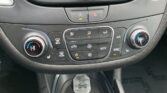 Center console of a car showing climate controls: left and right temperature dials, row of buttons for air flow, defrost, A/C, AUTO and SYNC, and a hazard light button above.