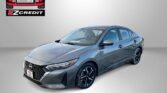 Gray Nissan sedan photographed at an angle with Easton Motors EZCredit logo in the top left and 'APPLY, ARRIVE & DRIVE!' slogan at the bottom.