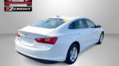 White Chevrolet sedan shown from rear three-quarter with dealership logos (Easton Motors, EZCredit) in a gray studio background; slogan 'APPLY, ARRIVE & DRIVE!' at bottom