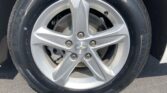 Close-up of a Chevrolet alloy wheel with a mounted tire, showing the center cap with the Chevy logo and brake components behind the spokes.