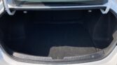 Open car trunk showing a spacious black fabric cargo area with rear hatch raised and small hooks on each side for securing luggage.