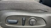 Car seat adjustment panel with a side lever, vertical switch, and round dial for seat positioning and lumbar support in a car interior.