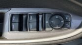 Driver-side door panel with four window switches and a round, multi-directional control pad for mirrors.