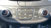 Close-up of a car climate control panel with dual temperature dials (both set to LO), central hazard light button, and surrounding airflow and A/C controls.